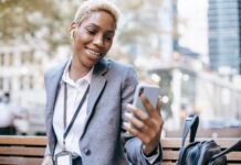 FCM’s AI Assistant ‘Sam’ Goes Live for South African Business Travellers woman smiling at her cell phone
