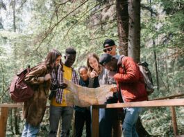 group of people standing outside in nature looking at a map
